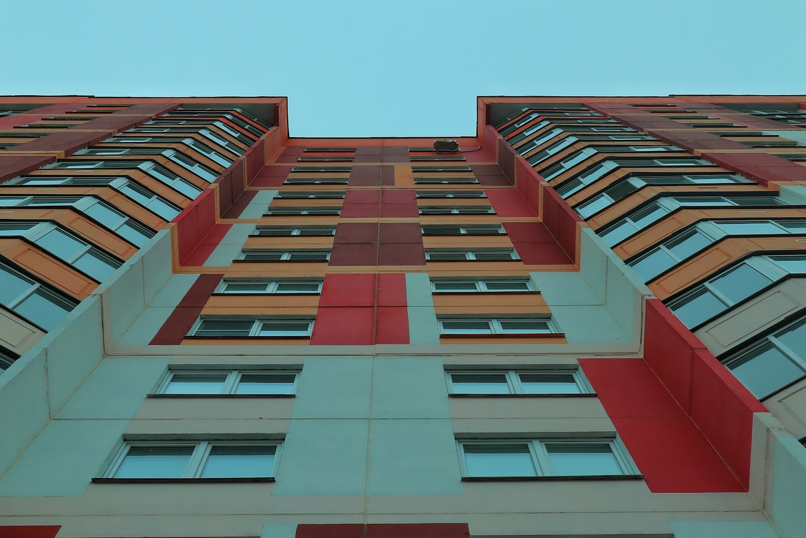 a tall multi - colored building with lots of windows